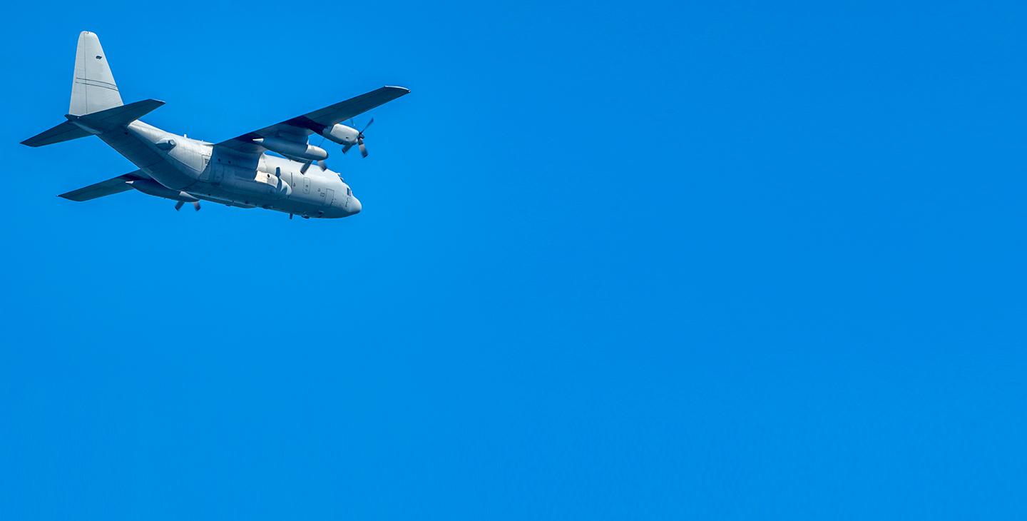 Aircraft flying against a bright blue sky, utilizing dual-band antennas for airborne communications